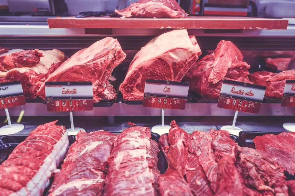 Fresh cuts of beef laid out in a butcher shop display counter